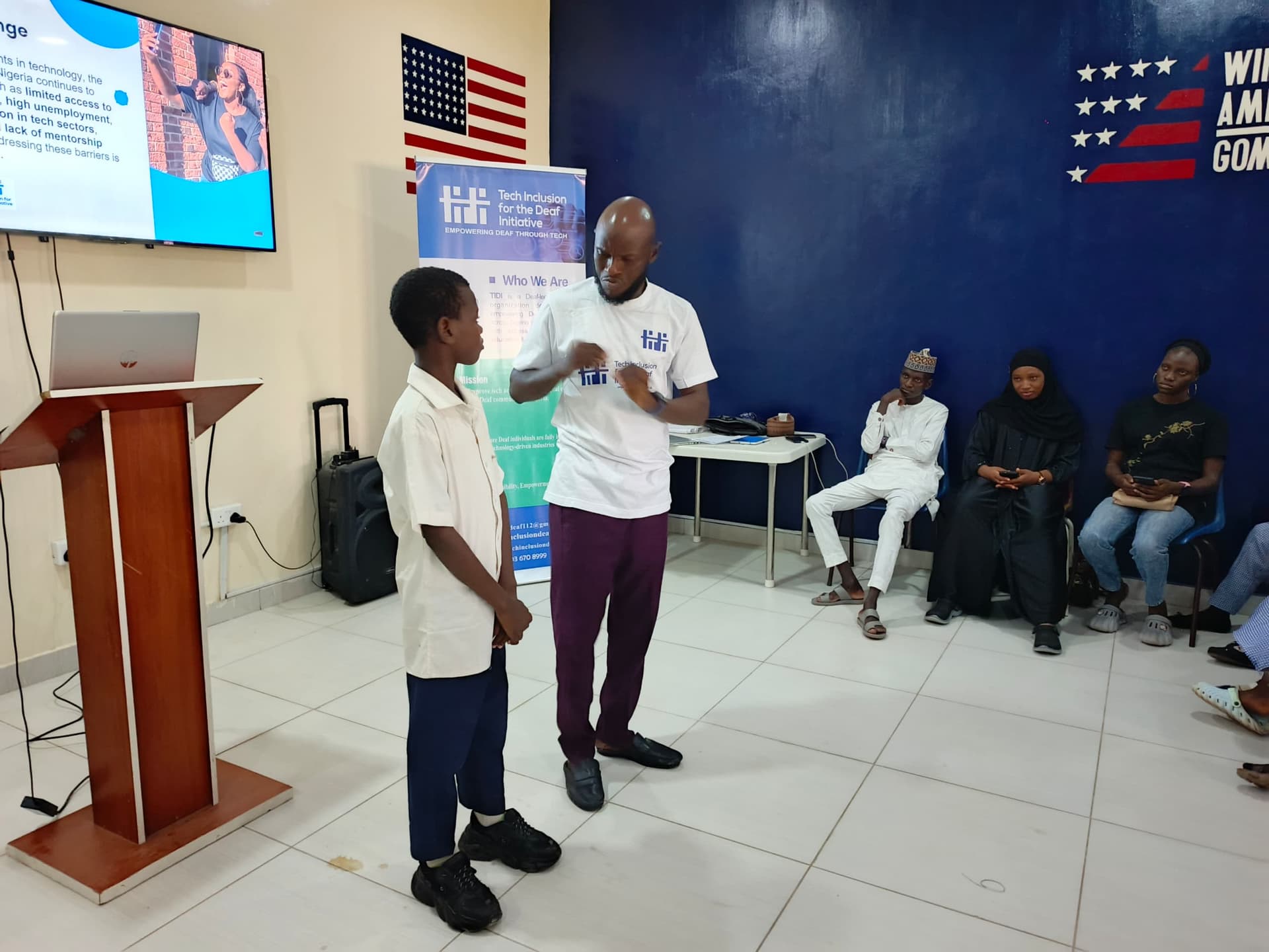 Student working on a laptop with signer